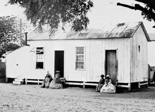 Well-dressed ladies sit in front of the Contraband office.